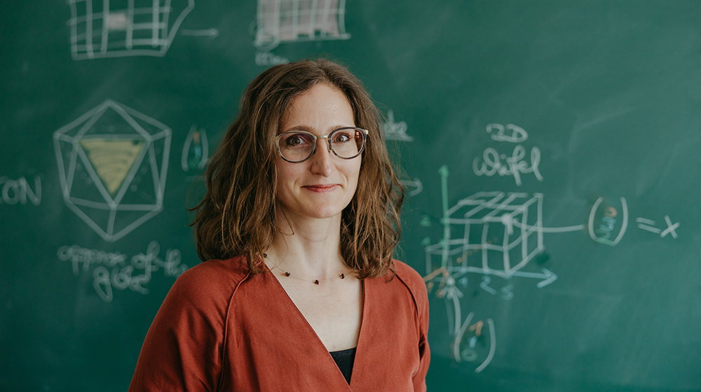 Prof. Petra Schwer vor einer Tafel mit geometrischen Formen (c) Jana Dünnhaupt Uni Magdeburg