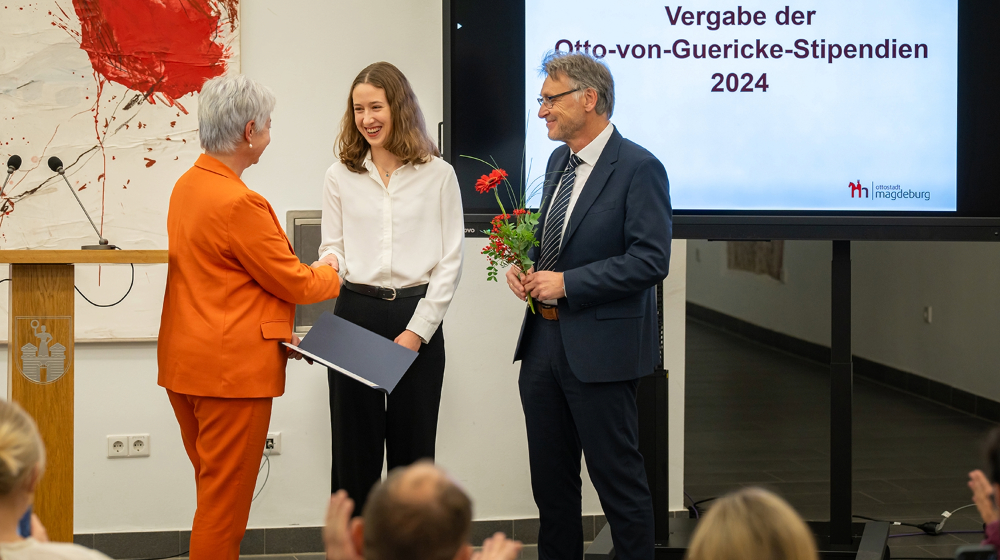 Bei der Vergabe des Stipendiums bekommt die Studentin Alina von Frau Stieler-Hinz eine Urkunde und von Prof. Strackeljan eine Blume übergeben (Foto: Laura Saalfeld / Landeshauptstadt Magdeburg)