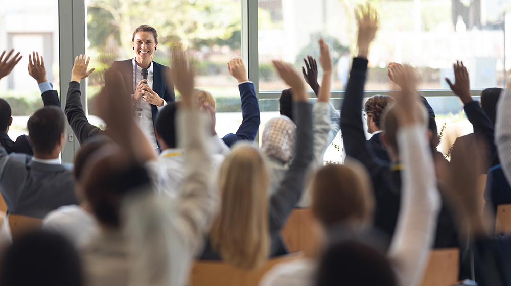 Eine Frau beantwortet Fragen aus dem Podium (c) Shutterstock wavebreakmedia