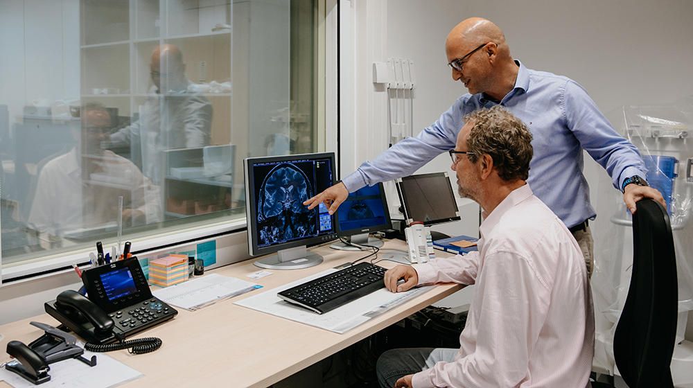 Im Kontrollraum des MR-PET Systems betrachten Prof. Düzel (hi.) und Dr. Kreutz (vo.) die Beschaffenheit der Hippokampusregion (Foto: Hannah Theile / Uni Magdeburg)