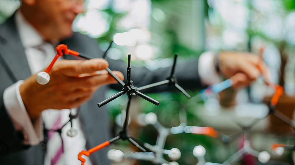 Prof. Dieter Schinzer hält das Molekül-Modell in der Hand (c) Jana Dünnhaupt / Uni Magdeburg