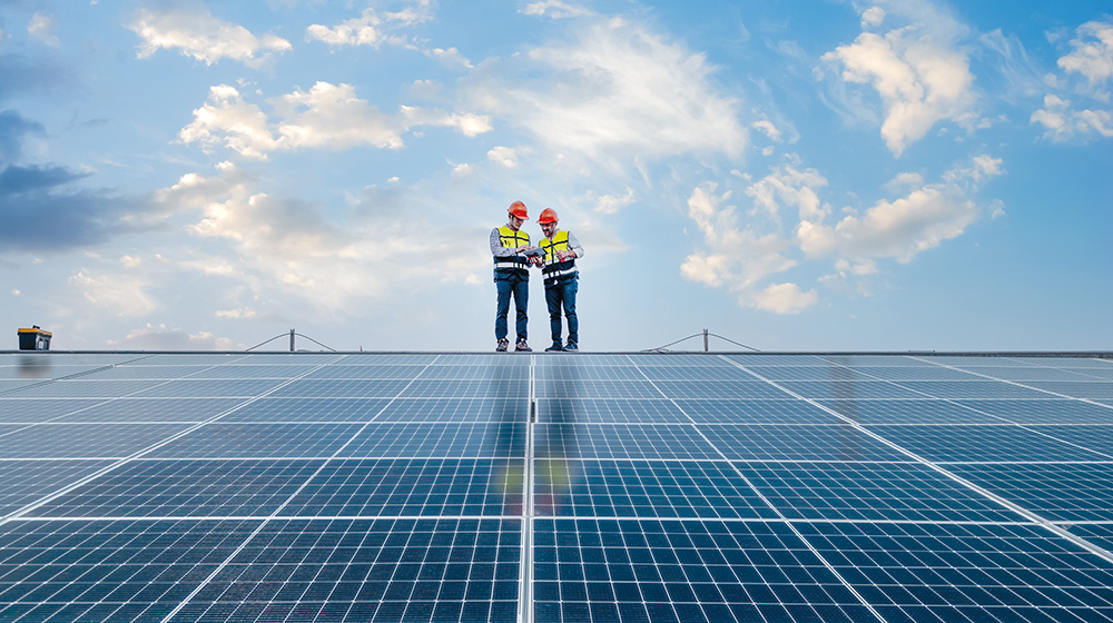 Zwei Männer begutachten eine große Photovoltaikanlage (c) Shutterstock APChanel