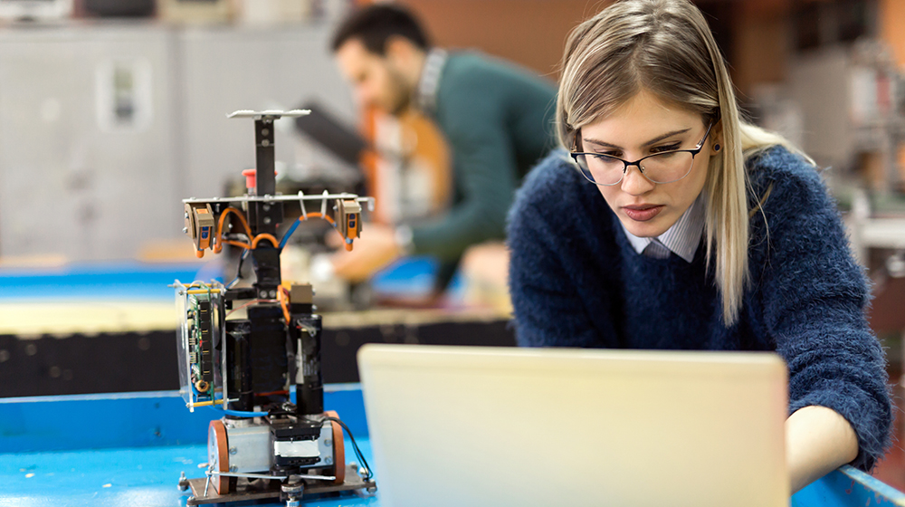 junge Frau programmiert einen Roboter (c) shutterstock NDAB Creativity