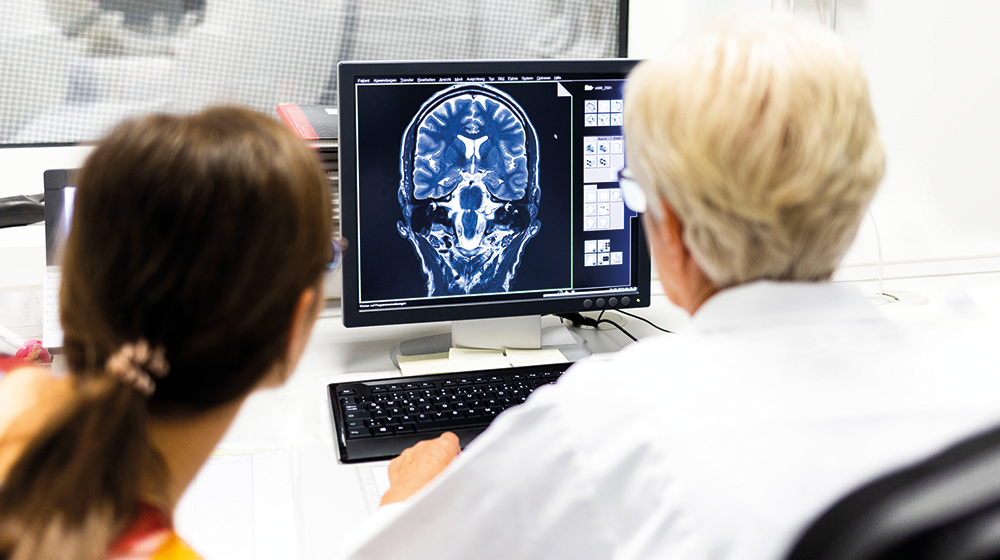 Two women examine an MRI image of a brain on a PC screen (c) Sarah Rinka