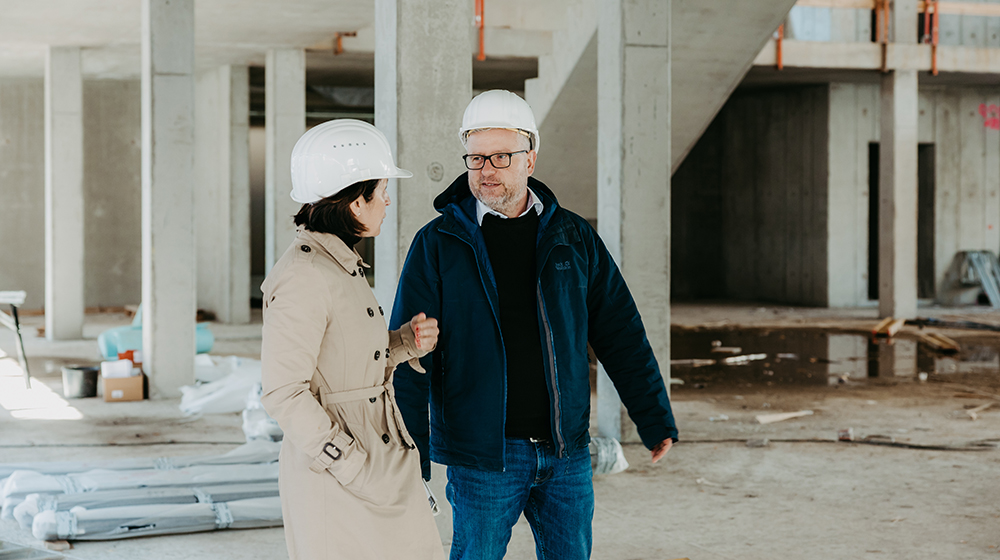 Baudezernent Clemens Klein und Pressesprecherin Katharina Vorwerk im Gespräch auf der Baustelle des Welcome Centers (Foto: Jana Dünnhaupt / Uni Magdeburg)