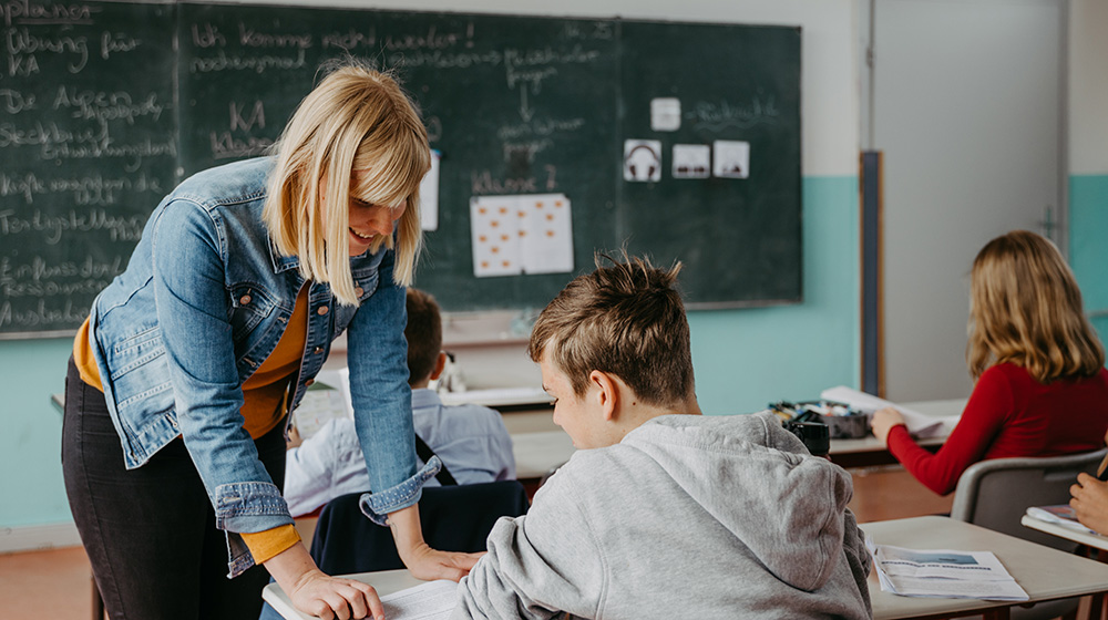 Lehrerin erklärt einem Schüler an seinem Platz eine Aufgabe (c) Jana Dünnhaupt / Uni Magdeburg