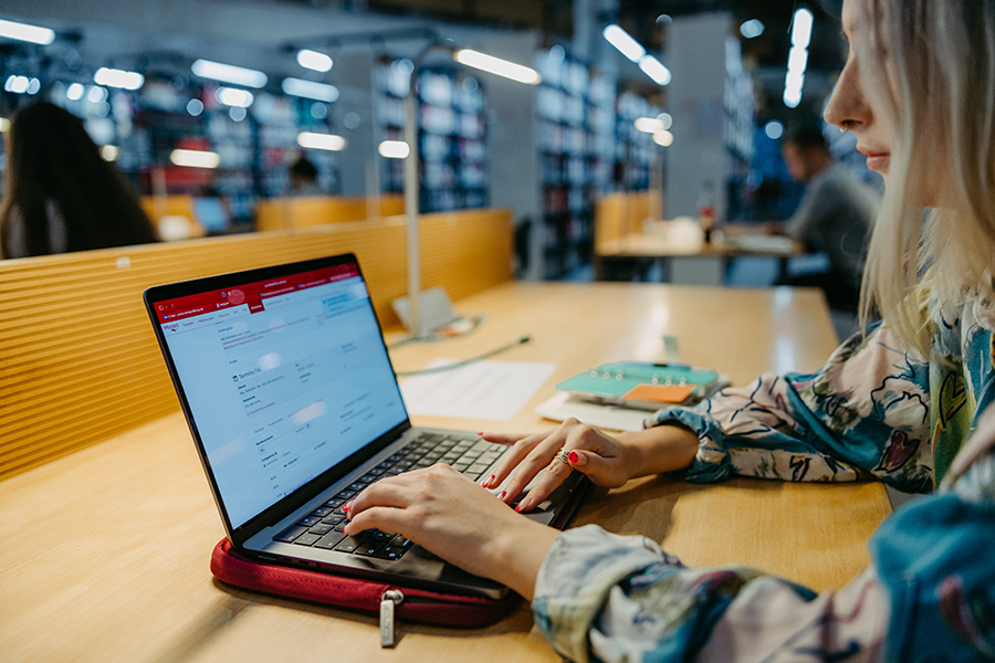 Studentin sitzt an einem Schreibtisch in der Universitätsbibliothek Magdeburg und arbeitet am Laptop (c) Jana Dünnhaupt Uni Magdeburg