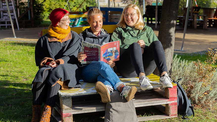 Three female students sit on pallet furniture and read the second issue of the student magazine tja (c) Anna Friese Uni Magdeburg