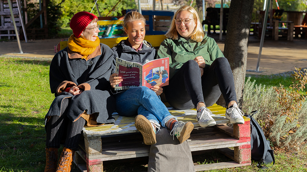 Drei Studentinnen sitzen auf Palettenmöbeln und lesen die zweite Ausgabe der Studierendenzeitschrift tja (c) Anna Friese Uni Magdeburg