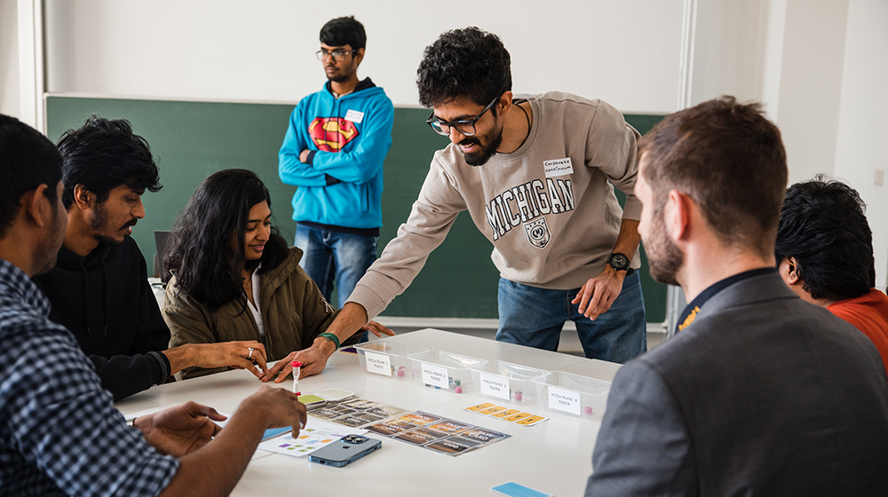Studierende sitzen bei der Lehrveranstaltung Serious Games an einem Tisch und spielen eines der entwickelten Spiele (c) Jana Dünnhaupt Uni Magdeburg
