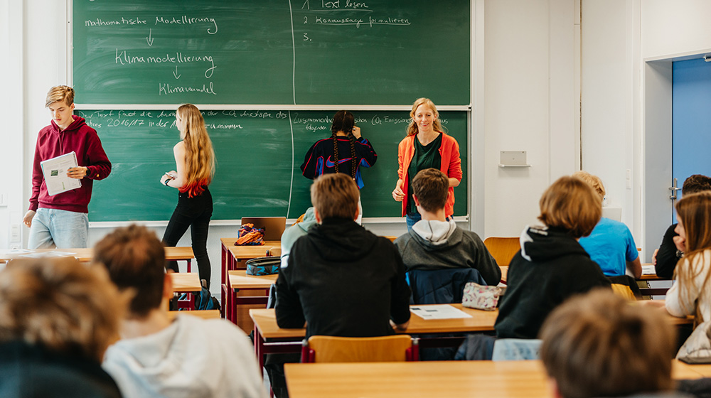 As part of the theme year, Dr. Mehlmann explains the connection between mathematics and climate change in a working group with school classes (Photo: Hannah Theile/Uni Magdeburg)
