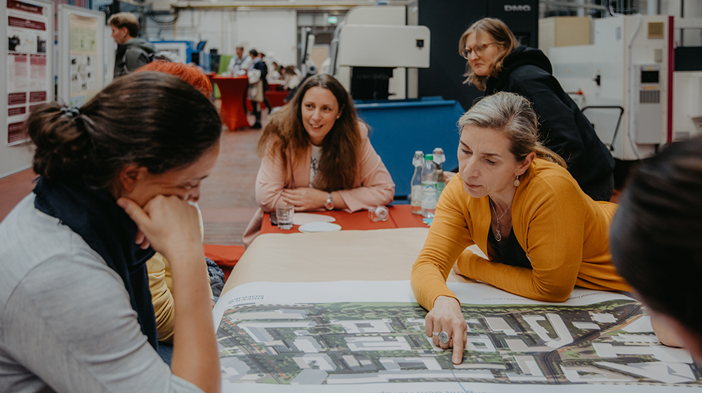 Studierende und Mitarbeitende der Uni Magdeburg tauschen sich an einem Tisch für die Gestaltung des Campus aus (c) Anna Friese Uni Magdeburg