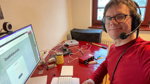 Prof. Kahle bei einer Podcastaufnahme (c) privat Prof. Kahle sitzt an einem Schreibtisch mit einem Headset vor einem Computerbildschirm und nimmt einen Podcast auf (c) privat