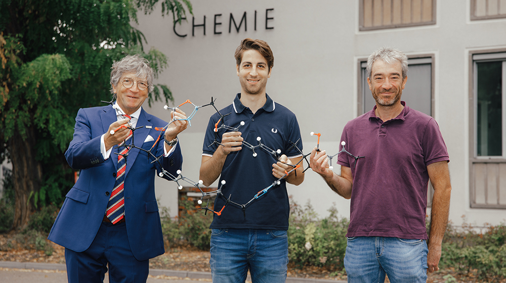 Das Team von Prof. Schinzer vor dem Gebäude des Instituts für Chemie mit einem Molekül-Modell (Foto: Jana Dünnhaupt / Uni Magdeburg)