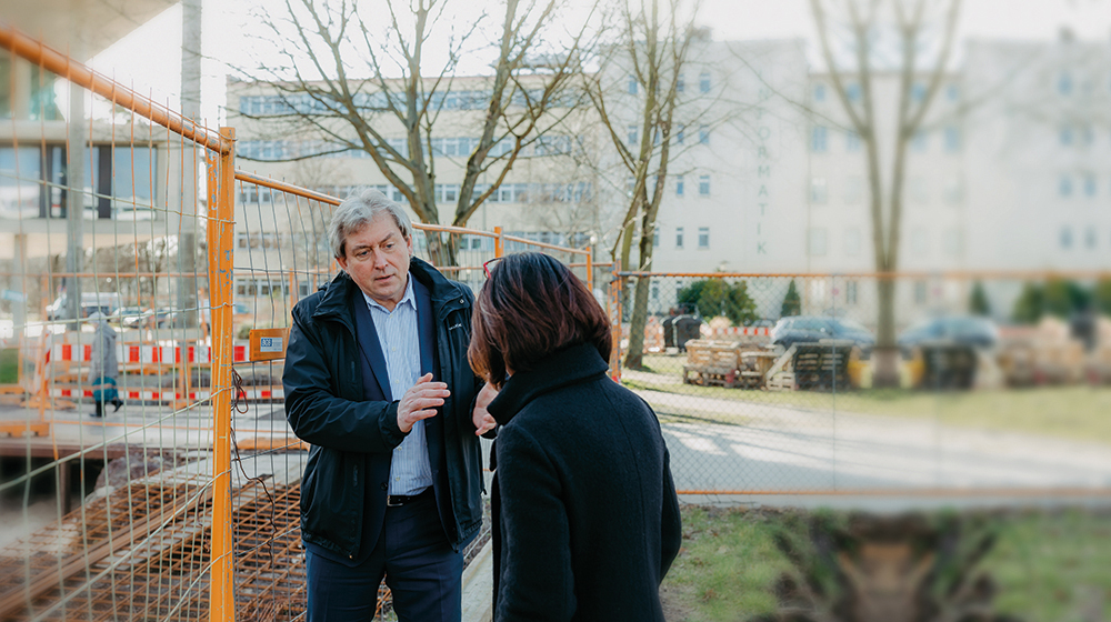 Der Kanzler der Uni Magdeburg Dr. Wadzack im Gespräch mit Pressesprecherin Katharina Vorwerk vor einer Baustelle auf dem Campus (c) Jana Dünnhaupt Uni Magdeburg