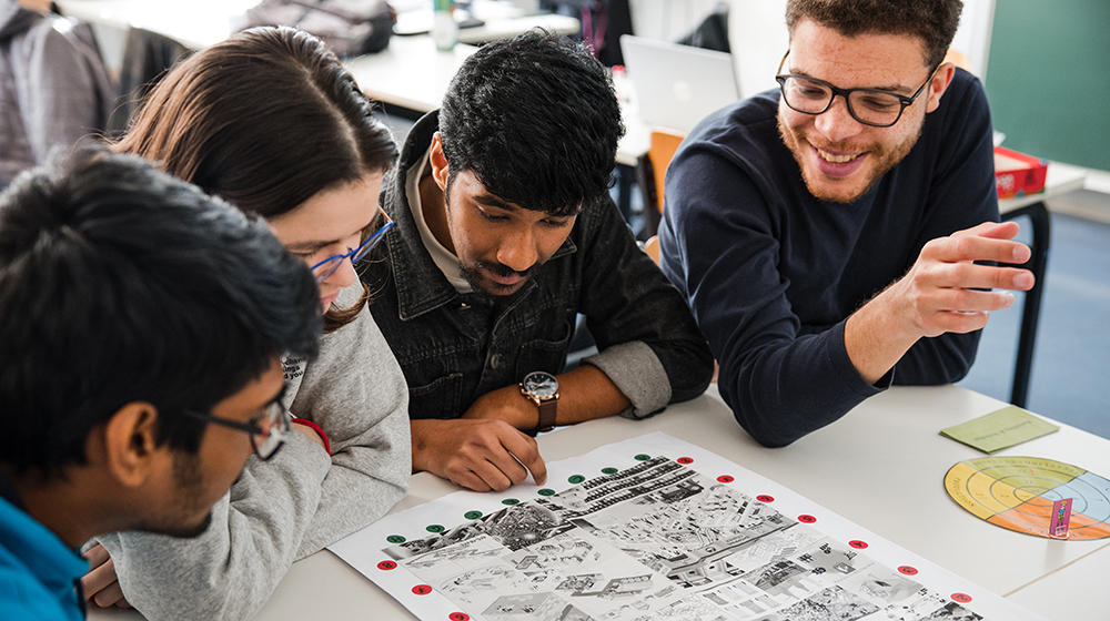 Studierende sitzen bei der Lehrveranstaltung Serious Games an einem Tisch und spielen eines der entwickelten Spiele (c) Jana Dünnhaupt Uni Magdeburg