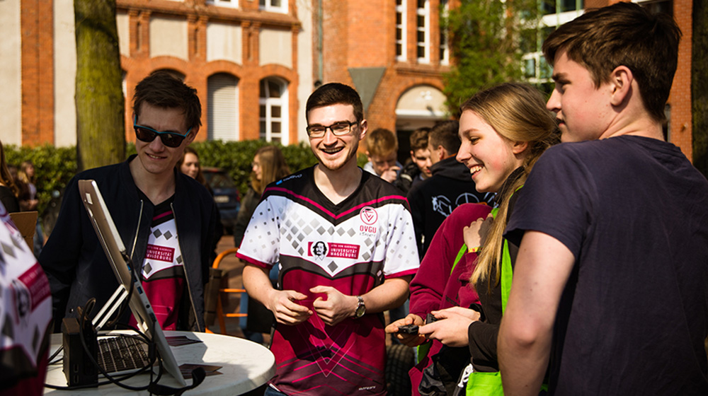 Nico Siebert vom OVGU eSports-Team (2.v.l.) erklärt Schülern des Norbertusgymnasiums Magdeburg beim Presseauftakt zum campusdateLIVE, dem Studieninfotag an der Otto-von-Guericke-Universität Magdeburg, ein Spiel am Computer.