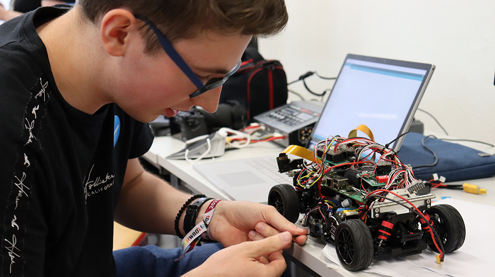 Pupils tinker with a car robot at the Robot Olympiad (Photo: Technik Begeistert)