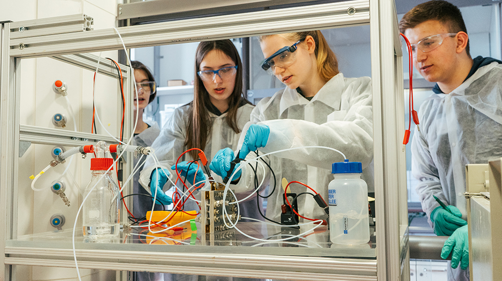 Schülerinnen und Schüler stehen im Labor und experimentieren mit einer Brennstoffzelle beim Schülerpraktikum (Foto: Nils Thomas / Max-Planck-Institut Magdeburg)