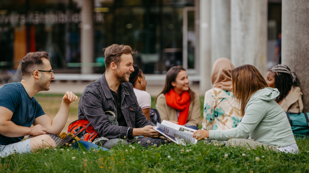 Students sitting on a meadow on the campus of the University of Magdeburg (c) Jana Dünnhaupt University of Magdeburg