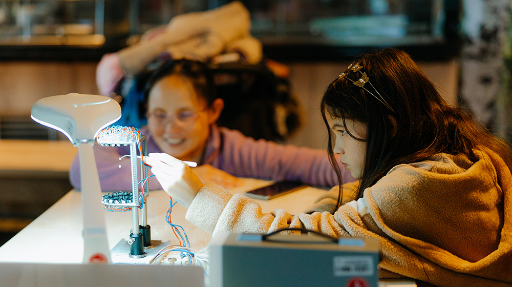 Zwei Mädchen bei einem Experiment beim Tag der Physik (c) Jana Dünnhaupt Uni Magdeburg