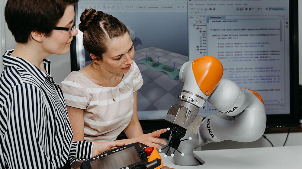 /unimagdeburg_media/Forschung+_+Wirtschaft/Banner+Forschung/Zwei+Frauen+arbeiten+an+einem+Kuka_Roboterarm-height-560-width-1000-p-107584.jpg