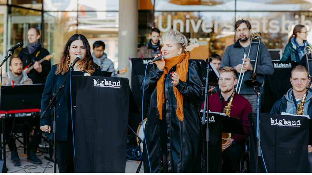 /unimagdeburg_media/Presse/Bilder/Pressemitteilungen/2023/UniBigBand+bei+einem+Auftritt+vor+der+Universit%C3%A4tsbibliothek_+S%C3%A4ngerinnen+im+Vordergrund+%28c%29+Jana+D%C3%BCnnhauptUni+Magdeburg-height-560-width-1000-p-108034.jpg