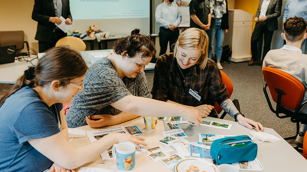 /unimagdeburg_media/Presse/Bilder/Pressemitteilungen/2023/Zwei+Mitarbeiterinnen+einer+Behindertenwerkstatt+und+eine+Studentin+lernen+gemeinsam+im+Rahmen+der+Werkstatt_Uni-height-560-width-1000-p-109416.jpg