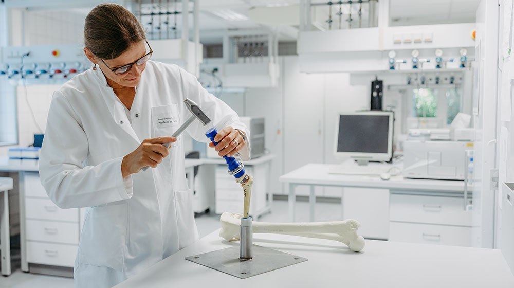 /unimagdeburg_media/Presse/Bilder/Pressemitteilungen/2025/Prof_+Bertrand+im+Labor+mit+einem+Knochen+und+einem+Implantat+%28c%29+Jana+D%C3%BCnnhaupt+Uni+Magdeburg-height-560-width-1000-p-118324.jpg