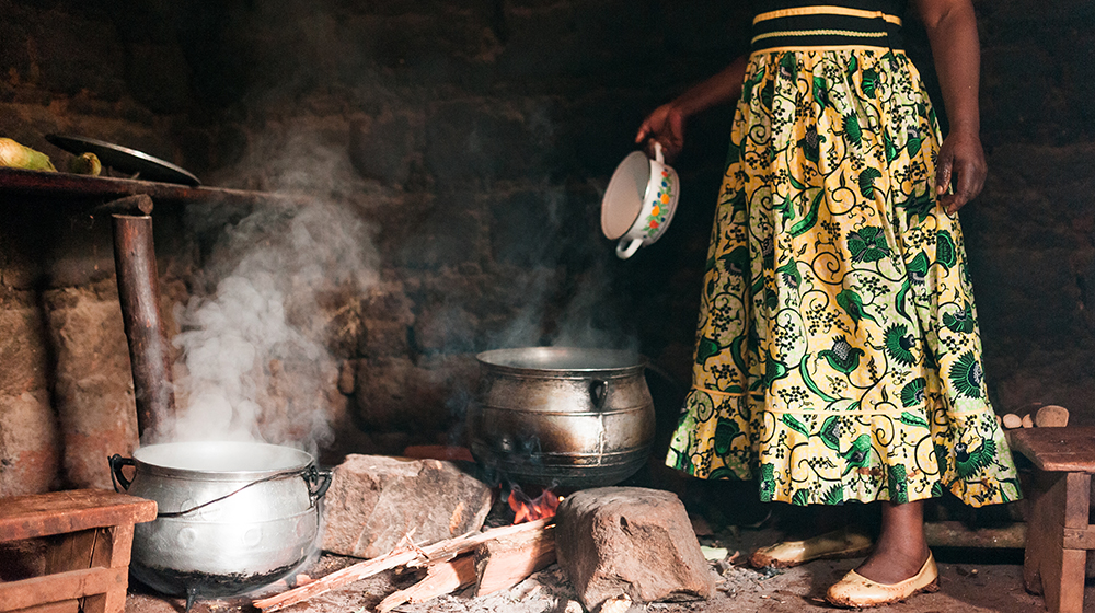 afrikanische Frau kocht über offenem Feuer (c) Shutterstock davide bonaldo